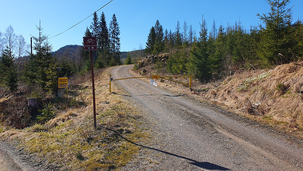 Den låste bommen ved krysset rett nord for Naphaug. Åsen som stikker opp i bakgrunnen like til venstre for sykkelskiltet, er Nordkollen (358).