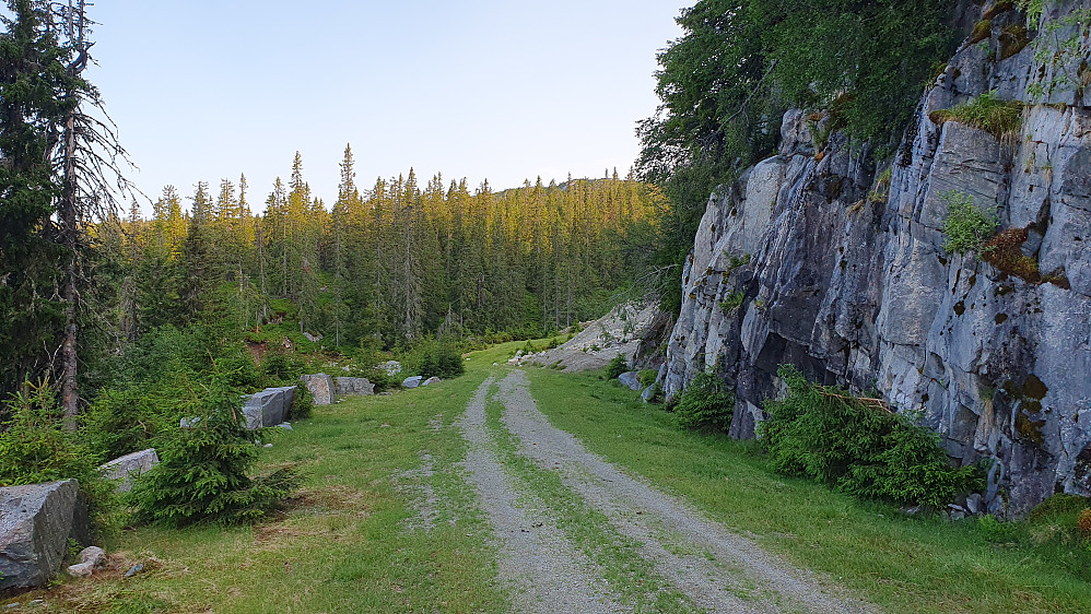 Straks framme ved traktorveien som tar av opp mot høyre borte ved grustaket, som ses på høyre side etter fjellskjæringen.