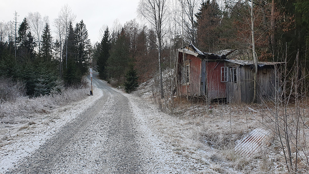 Vandring på grusveien mellom noen bygninger som har sett bedre dager. Også her sto det en oppreist bom.