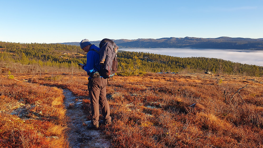 På stien vi fulgte oppover øst for Nutenutan. Nuten er i bakgrunnen, delvis bak Øyvind og like til venstre for han. Over Tunhovdfjorden ligger fortsatt tåka.