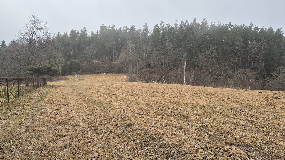 På vei mot turens siste og laveste topp, Brastdalsåsen (113). Her går jeg langs en kirkegård.
