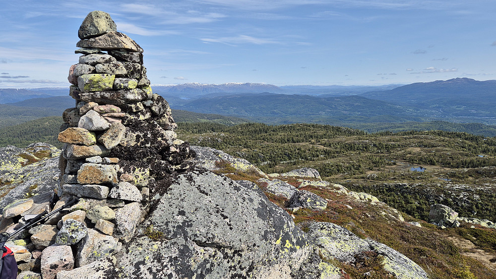 Toppvarden på Stavslinuten (1154). Bildet tatt mot nord. Like til høyre for varden, og helt bakerst, er det nysnø på de høyeste fjellene som f.eks. Fliseggi (1630) og Husnuten (1609). Fjellet helt til høyre i bildet er Vehuskjerringi (1355).