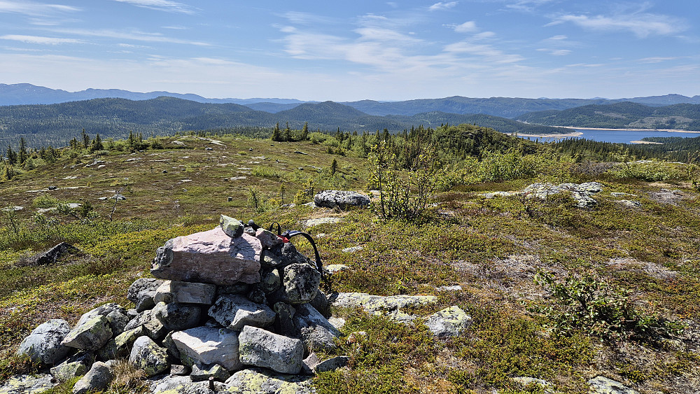 På toppen av Lislefjell (972). Utsikt mot sørvest. Det nedtappede Breivatn ses helt til høyre i bildet. Fjoshovden (971) er den ganske markerte og helt skogkledde åsen nokså midt i bildet. Bisminuten (992) er den noe slakere åsen mer til venstre.