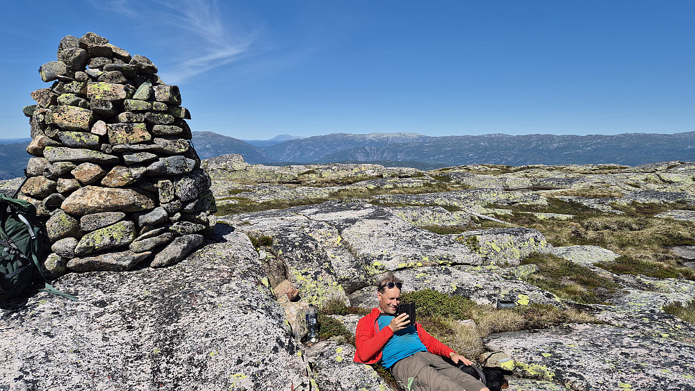 Vi nyter den praktfulle dagen på toppen av Mannslagarnuten (1074). Utsikt nordover. Det grå og høye fjellplatået langt bak nokså midt i bildet, er Mælefjell (1414). Gaustatoppen (1883) ses aller bakerst og litt til venstre.