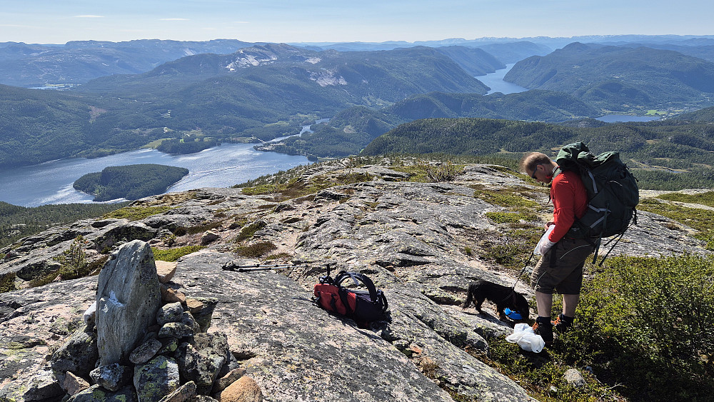 En liten matbit og noe drikke før den lange nedstigningen til bilen. Her står vi ved varden på trig.punktet på 1032 moh, hvor utsikten er aldeles praktfull. Bildet tatt mot vest/sørvest. Vannet langt nedenfor til venstre er Kviteseidvatnet. Den fjordaktige innsjøen bak til høyre er Bandak.