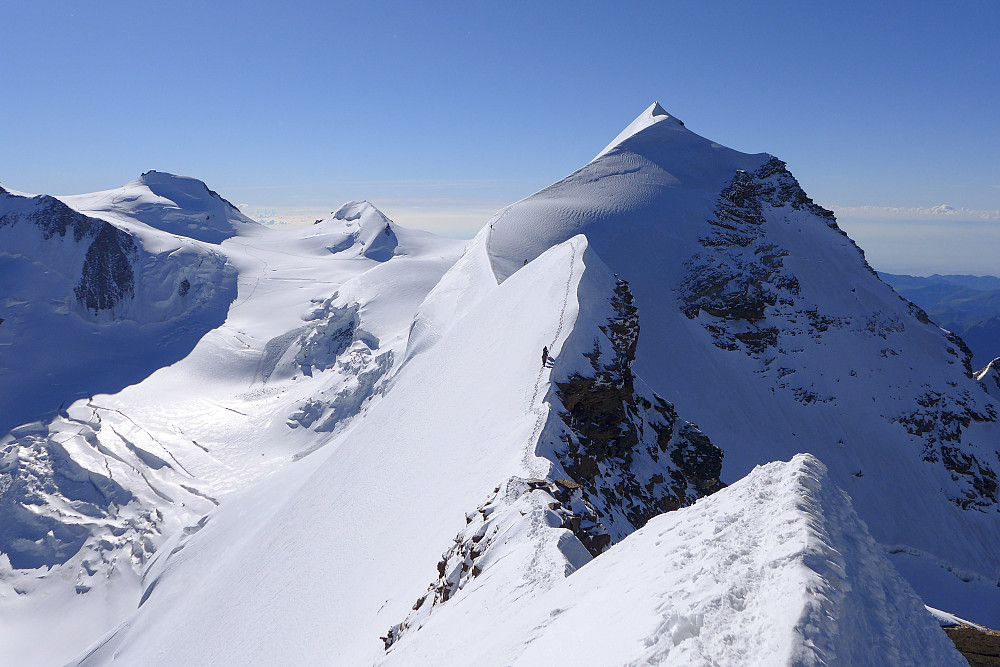The beautiful snow ridge leading toward the eastern summit of Lyskamm, with a group of climbers midway