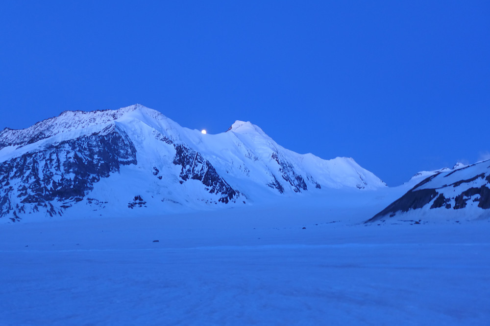 Blue hour over the Aletschhorn with the moon just peeping over the ridge