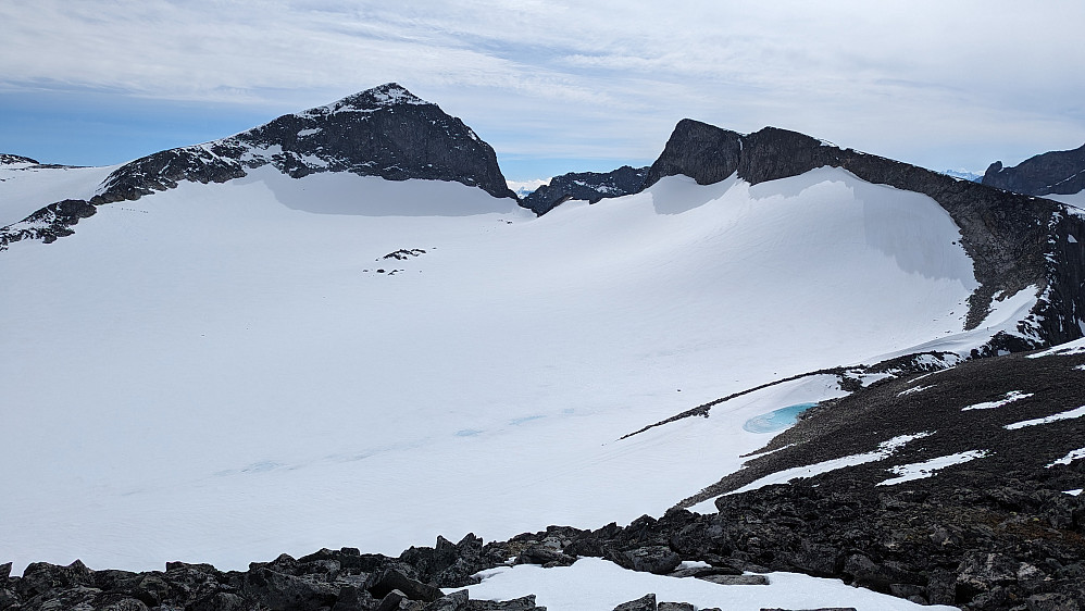 Utsikt fra Galdhøe. Galdhøpiggen med Vesle Galdhøpiggen til høyre. I breen foran Galdhøpiggen kommer det gradvis frem blokker i snøen når breen minker. I Peakbook heter "toppen" Nunatak øst for Porten.