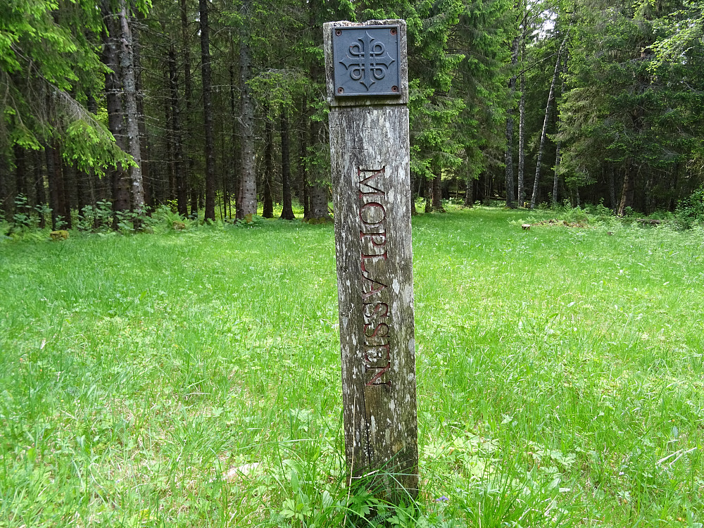 En pilegrimsstolpe på Monaplassen som er tæret av tidens tann
